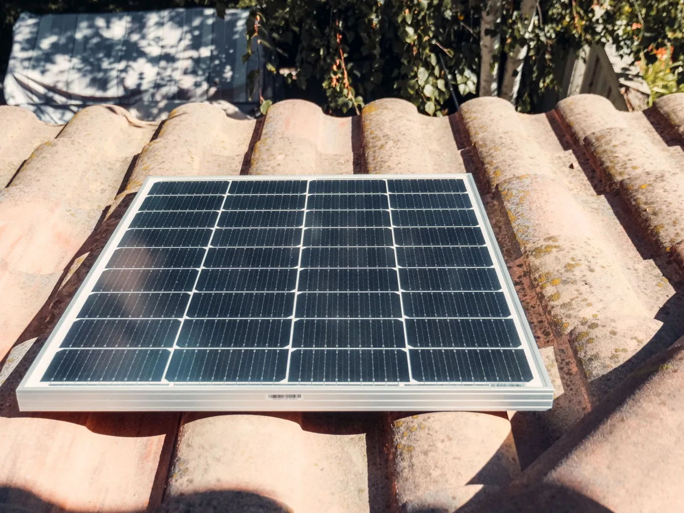 malý solární panel položený na střešní tašce