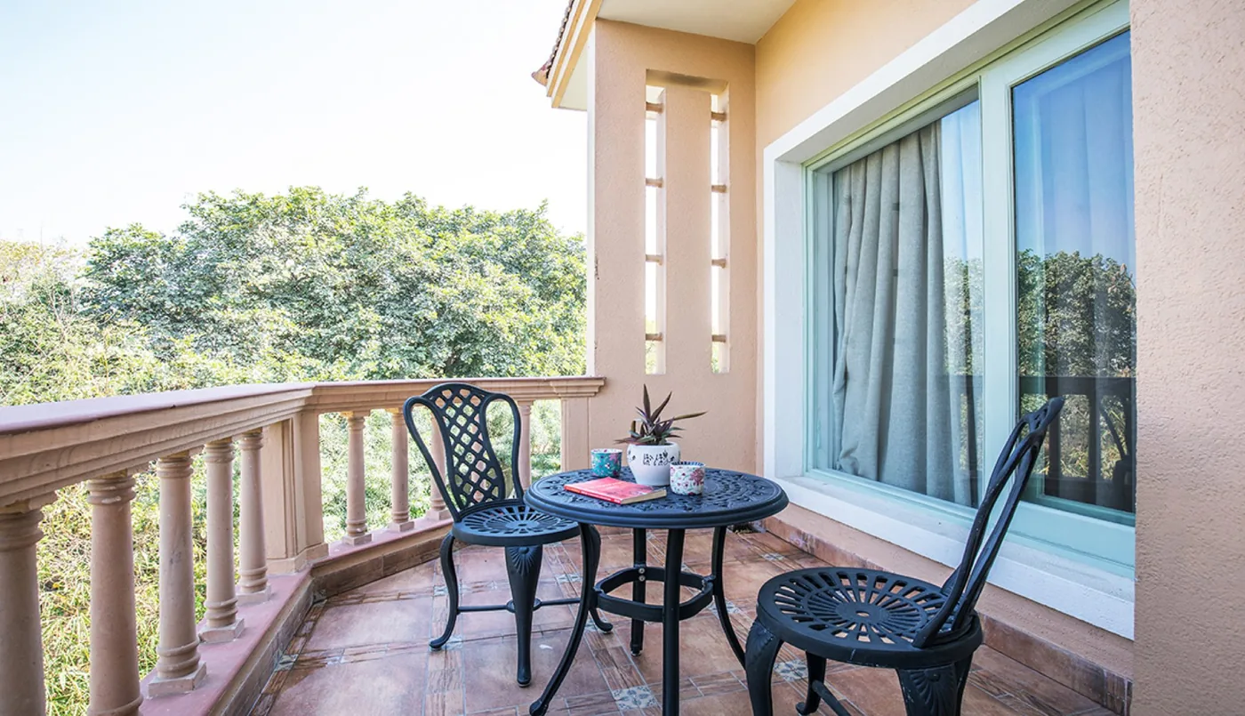balkon s kulatým stolkem a dvěma židlemi