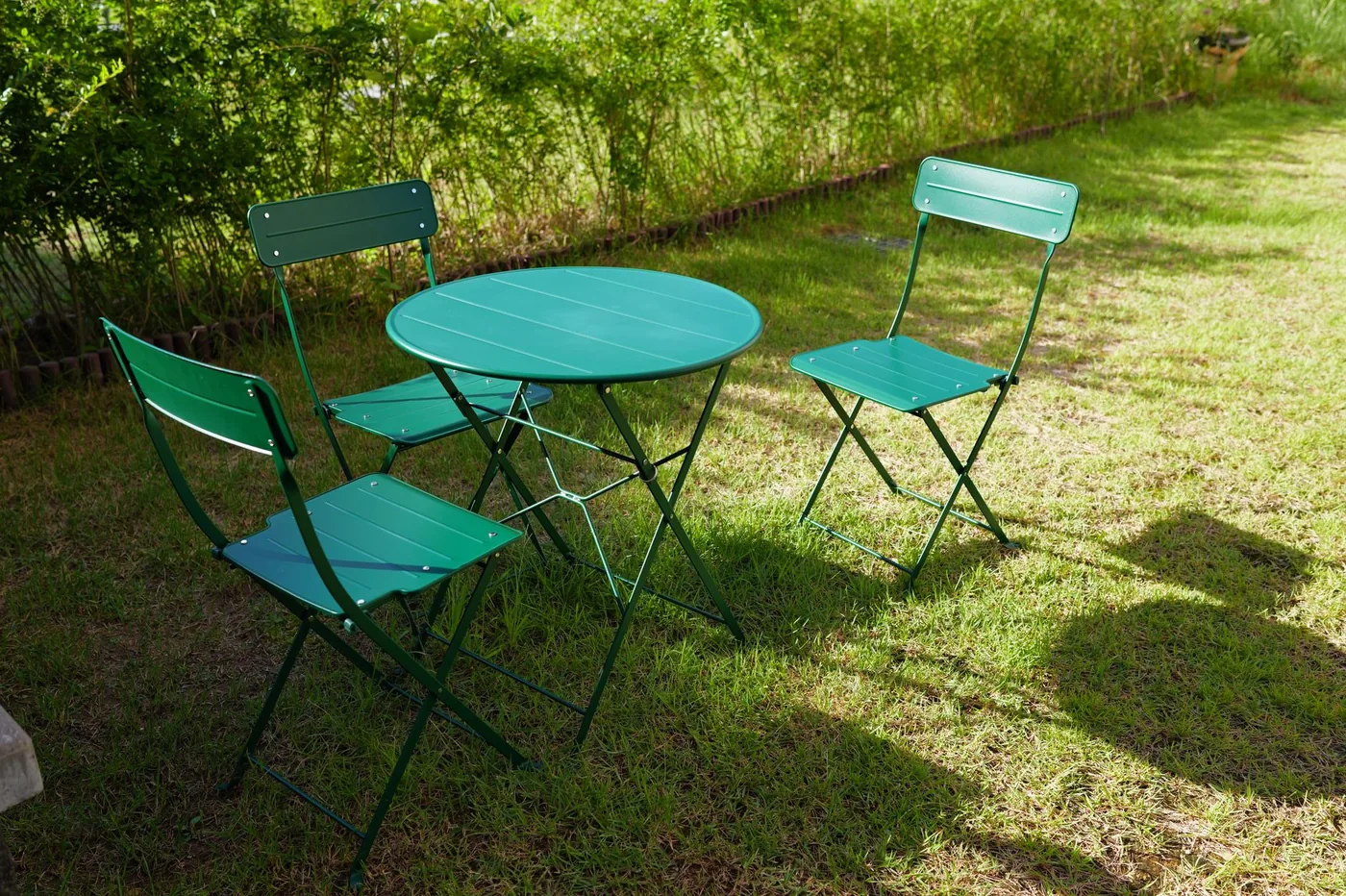 zelený skládací bistro set na trávníku