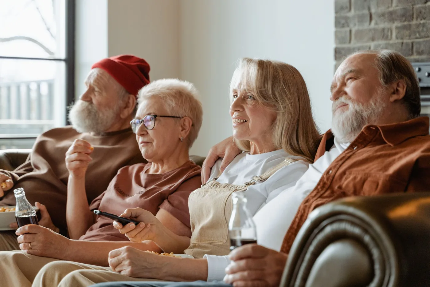 skupina seniorů sedí pohromadě na gauči
