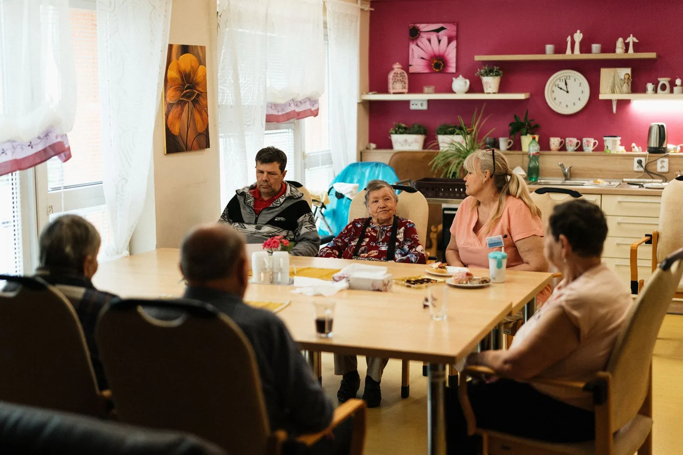 skupina seniorů sedí u společného stolu
