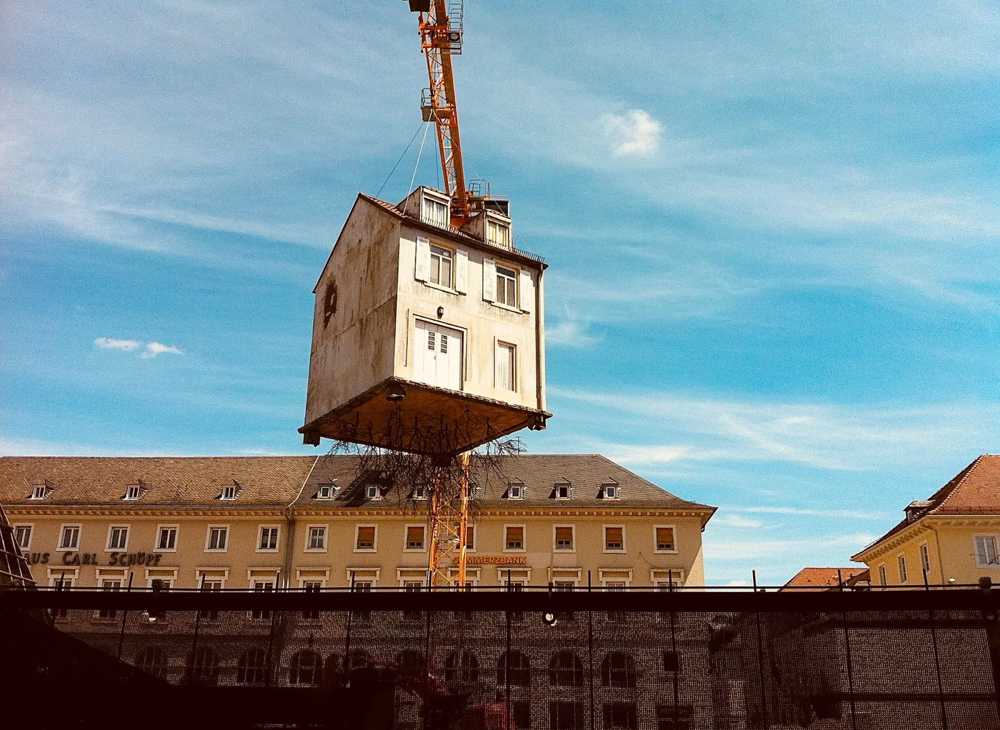 dům zavěšený na jeřábu nad městem