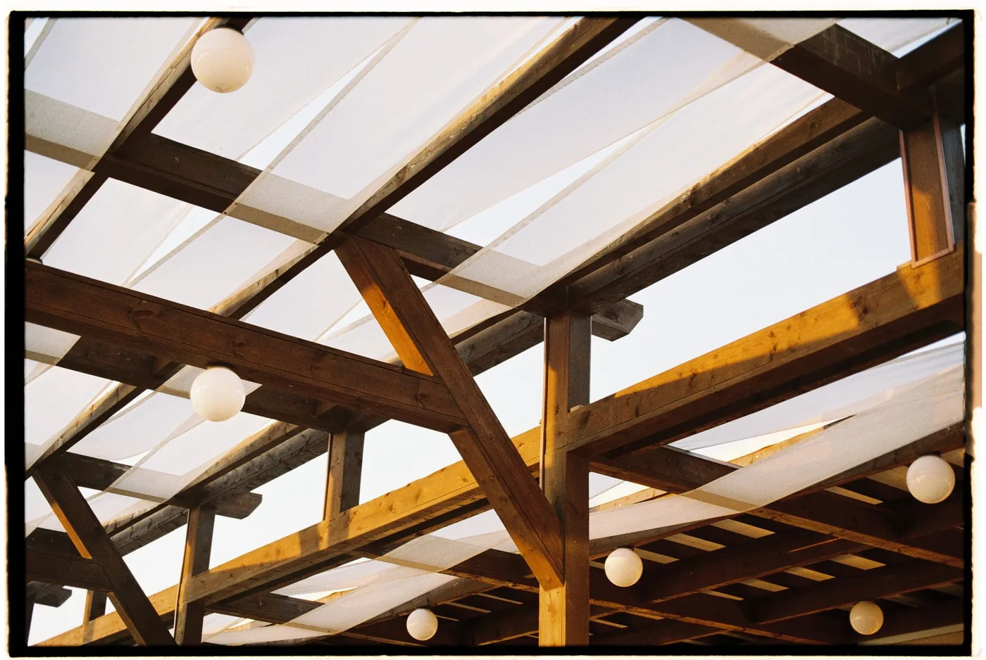 dřevěná pergola s bílou plachtou a lampiony