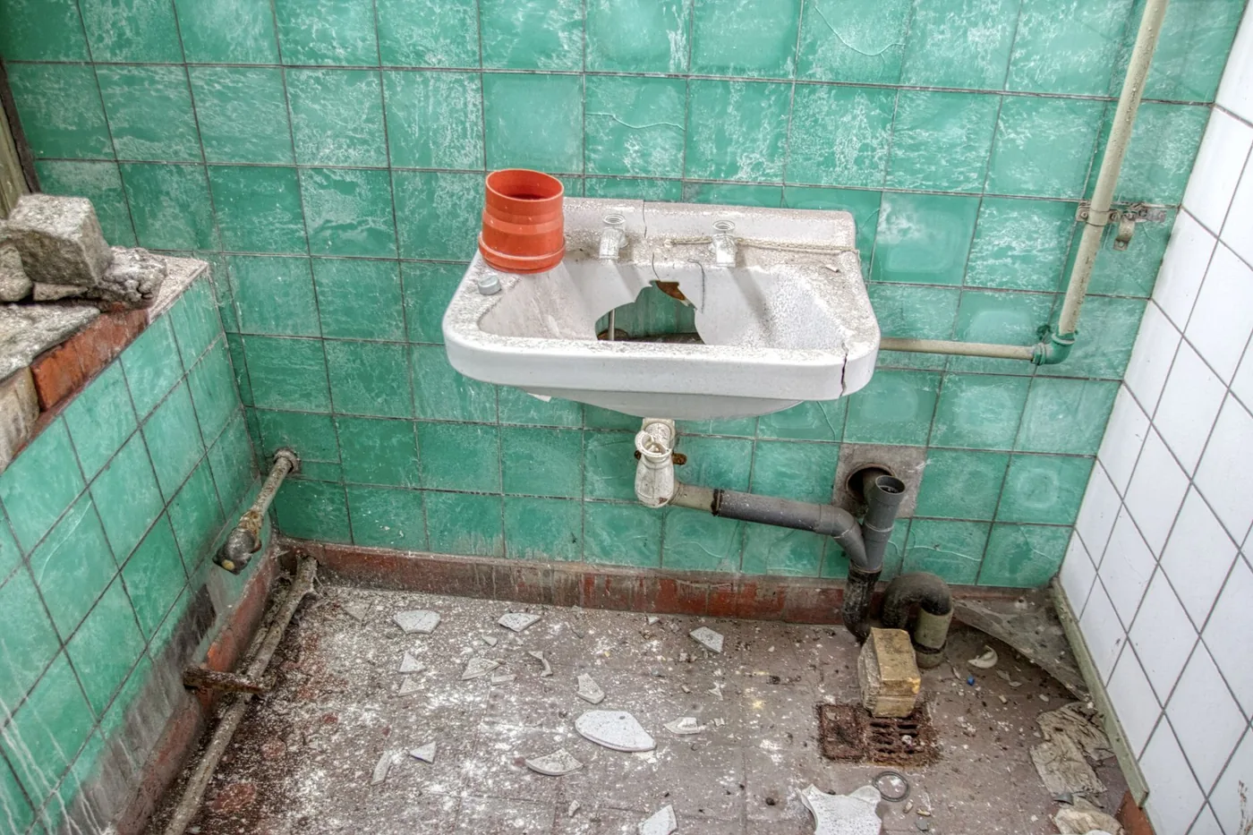 zchátralá koupelna s rozbitým umyvadlem