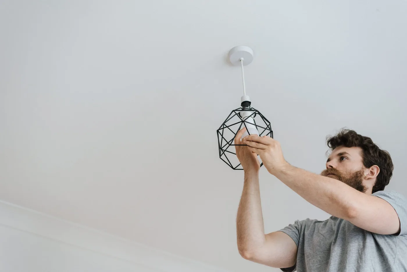 muž montuje geometrické stropní svítidlo