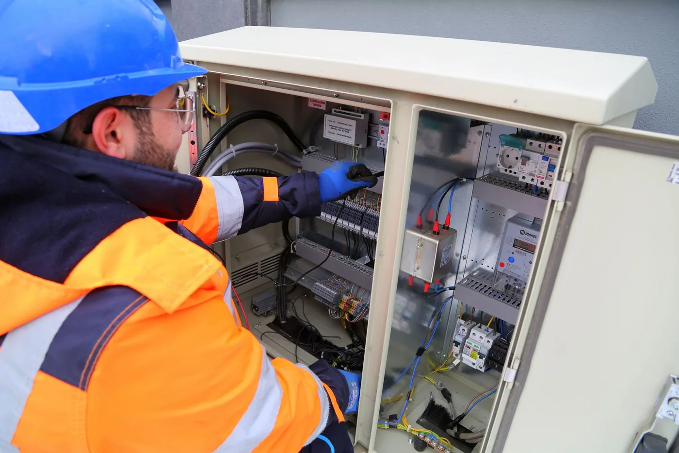 elektrikář kontroluje otevřený venkovní rozvaděč