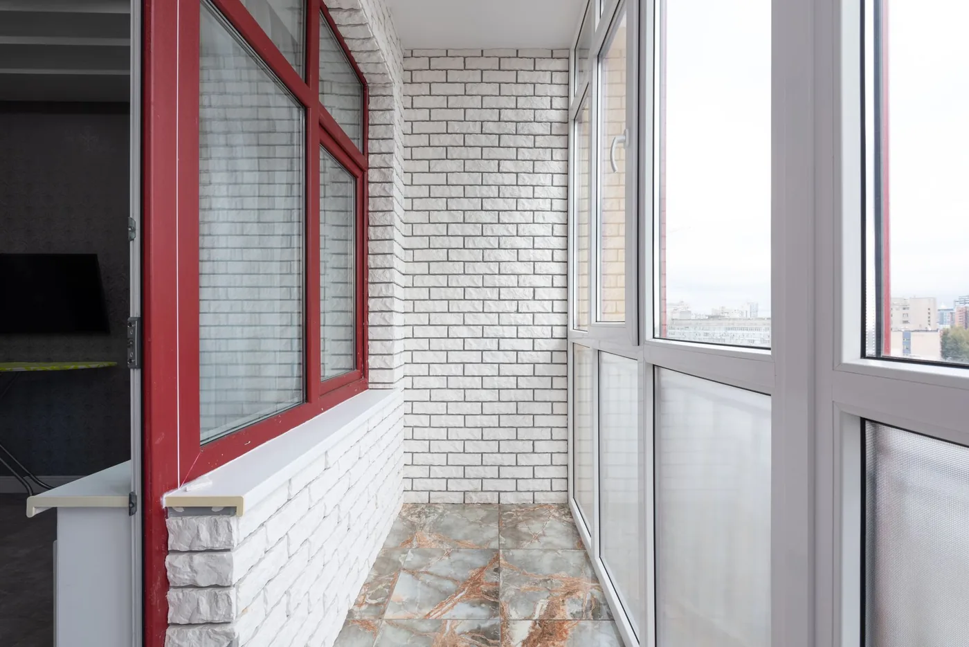 zasklený balkon s červenými hliníkovými rámy